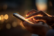 © Zulkifle - Hands use a glowing smartphone at night against a blurry bokeh background. Symbolizes digital connection, technology, communication, and modern-day life.