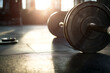 © Starmarpro - Barbell with weights on gym floor. Ready for a workout to build muscle strength and get into shape, weightlifting background and golden hour.