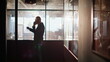 © stockbusters - Silhouette manager talking cellphone in office corridor. Businessman finish call
