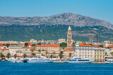 SPLIT, CROATIA – July 16, 2019: Panoramic view of Split Riva with Diocletian's Palace, palm trees, and Jadrolinija ferries on a sunny summer day