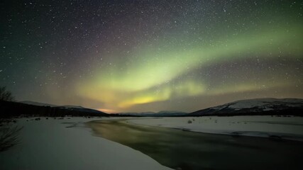 Wall Mural - A high-angle, long exposure time-lapse captures the subtle shifting of a pale yellow and green aurora over a frozen river nature, discovery, science