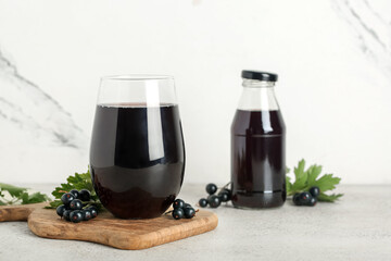 Wall Mural - Glass and bottle of fresh black currant juice on white background