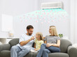 © New Africa - Happy family on sofa in room with air conditioner