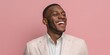 © Pro Hi-Res - Smiling man in a light blazer poses against a pink background showcasing joy and confidence in a playful setting.
