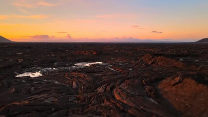 Wall Mural - Textured hardened lava field glowing in warm golden hour light cracked earth, volcanic rock, warm light