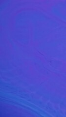 Wall Mural - Vertical video. Liquid texture. Wave ink. Defocused blue neon color chemical paint in water spreading on enamel marble abstract background.