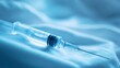 © Ainmanation - Transparent Syringe on Soft Fabric Near a Bright Blue Background