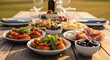 © BUDI - Outdoor picnic table laden with appetizers and drinks.  A casual,  elegant meal outdoors