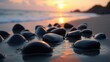 © diki - Close-up view of dark stones at the water's edge during a beautiful sunset over the ocean.