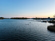 Calm lakeside at sunset with boats and distant town on the horizon for stock use in Vienna, Austria.