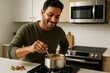 © Who is Danny - Man happily stirring chai in stainless steel pot on stove in modern kitchen with warm light and neutral background. Ai generative. Ai generative