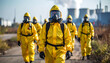 © Fitria - People in yellow hazmat suits walking towards a factory.