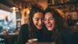 © imagemir - Two young women joyfully laughing together in a cozy café, showcasing their close friendship and vibrant personalities.