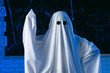 © kinomaster - A person in a white ghost sheet stands in a blue lit room and gestures to indicate an idea