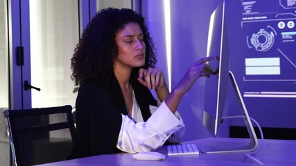 Latin businesswoman programmer is sitting typing code at a computer screen thinking of an application to create a company security system and prevent data theft as a computer IT crime