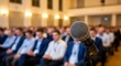 © Alamin - Microphone in focus on stage with blurred audience in a conference hall