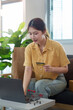 © Natee Meepian - Online Shopping. Young woman using laptop and credit card for e-commerce purchases.