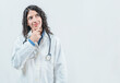 © IHERPHOTO - Young female doctor thinking with her hand on her chin, isolated. Thoughtful young female doctor looking up, isolated