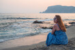 Woman sits on the beach and looks at the sea in Alanya city
