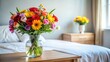 © PIMCHANOK - A bouquet of colorful flowers with a vase on a bedside table
