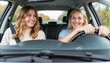 © Anna K@S - Two women smiling while driving a car on a sunny day
