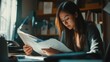 © alea - Concentrated student reviews documents in a cozy home study space