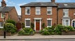 © Jawad - Exterior view front door and garden of a beautiful old red brick town house on a street in an english city