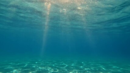 Wall Mural - mesmerizing slow-motion view of sun rays piercing through shimmering underwater ocean currents vibra