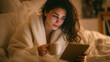 © Nova Zigres - Latina Woman Tracking Sleep Quality on Tablet in Bed with Tea