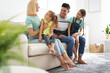 © New Africa - Happy family with children on sofa indoors