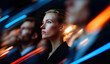 © Parisa - Business portrait of determined woman in audience with colleagues and dynamic red and blue neon streaks