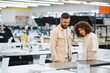 © Serhii - Couple exploring home appliances in electronics store