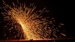 © FanFan_Studio - Industrial scene with glowing orange sparks in motion against dark background, metalworking abstraction.