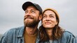 © DreamGrid - Happy couple looking up at the sky with hopeful expressions on their faces.