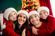 © deagreez - Joyful family celebrating Christmas together at home in cozy red sweaters near beautifully decorated tree