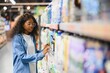 © Serhii - Interested young woman making purchases in household chemicals store, reading labels on bottles