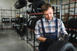 © Serhii - Portrait of a worker in a new car tire shop. Concept of changing tires