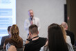 © Anton Gvozdikov - Audience in conference room listens to speaker with microphone during presentation