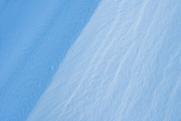 Wall Mural - Snow texture. Wind sculpted patterns on snow surface. Wind in the tundra and in the mountains on the surface of the snow sculpts patterns and ridges (sastrugi). Arctic, Polar region. Winter background