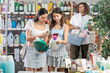 © JackF - Focused woman with teen daughter scanning barcode on bottle of laundry detergent using phones to get product information in home care shop while father of family browsing shelves in background