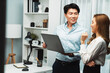 © InfiniteFlow - Smiling Asian coworkers standing while talking planning marketing report project on laptop casual day at modern office. Analyzing successful customer need in new social media online channel. Infobahn.