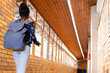 © wavebreak3 - African American child walking down school hall with denim backpack near windows and recycling bins