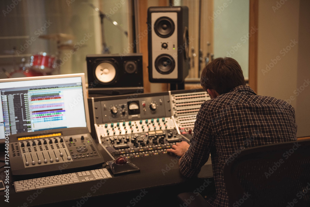 Sound Engineer Control Male sound engineer adjusting faders, knobs on mixing console in studio ...