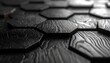 © nur - Close-up shot of dark, textured, hexagonal tiles in a repeating pattern, catching the light with sharp, angular edges, adding depth and dimension