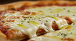 © Rizqi - A close-up captures the irresistible allure of a freshly baked pizza, showcasing melted mozzarella, vibrant tomato sauce, a glistening drizzle of olive oil, and scattered herbs, promising a burst of