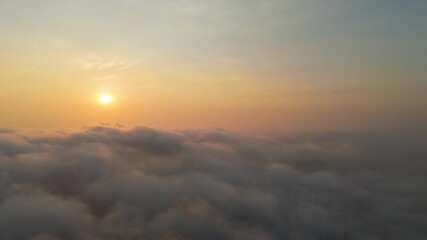 Wall Mural - Beautiful sunrise sky above clouds with dramatic light. View from above, flight over fog, sun low on horizon in mountains and ocean coast