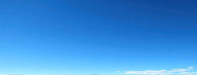 Wall Mural - Expansive blue sky fades slightly toward the horizon, dotted with small white wisps. Serene, open, and airy