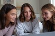 © Iryna - Young caucasian female friends enjoying time together and watching laptop