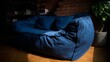 © fotogurme - Blue corduroy bean bag basks in cozy shadow, invoking Hygge comforts and International Nap Day coziness in urban loft