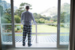 © wavebreak3 - Senior male standing on home balcony wearing pajamas leaning on railing overlooking lawn